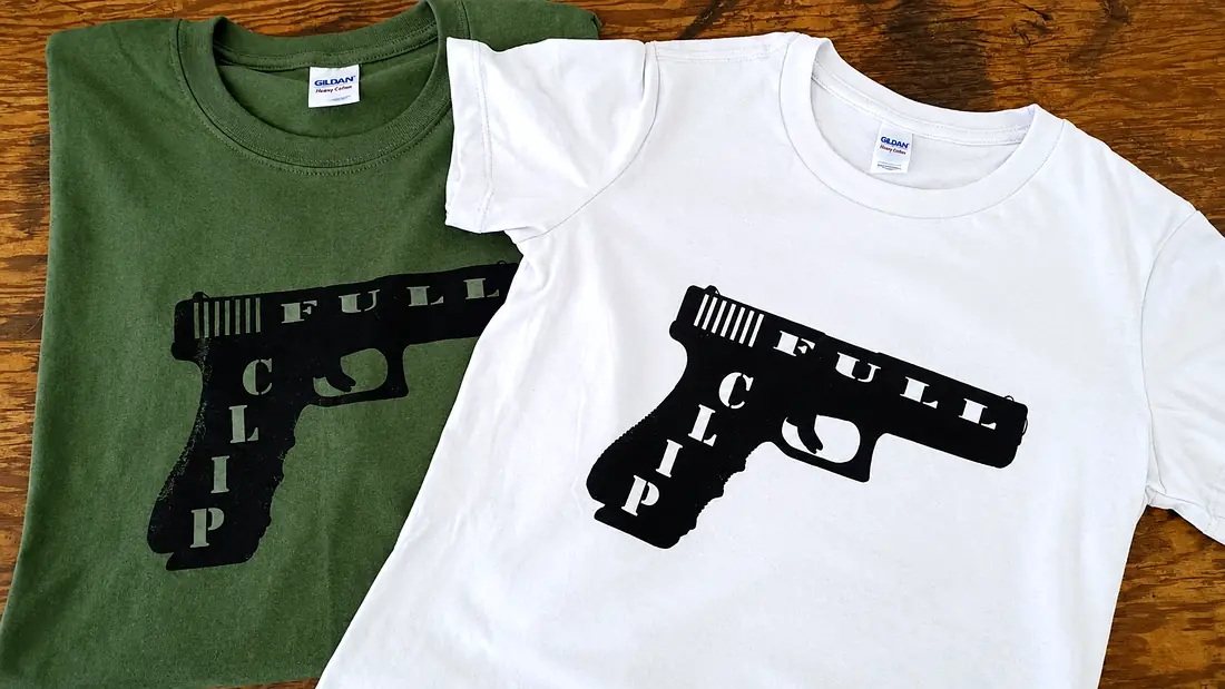 The same black graphic printed on a green shirt and a white shirt